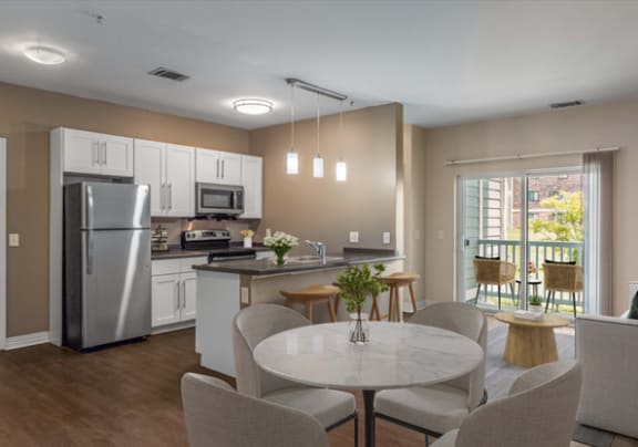 a kitchen and dining room with stainless steel appliances and a table and chairs at Rosemont Square in Randolph, Massachusetts