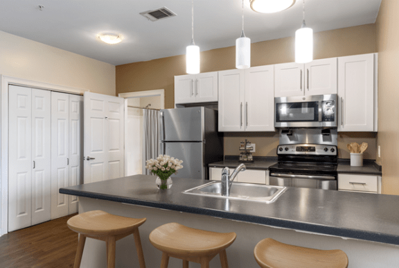 a kitchen with a counter top with stools at Rosemont Square in Randolph, MA 02368
