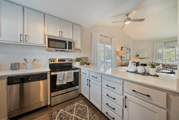 an open kitchen with stainless steel appliances and white cabinets