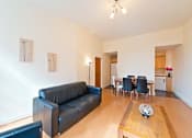 Thumbnail 5 of 6 - a living room with a leather couch and a wooden table