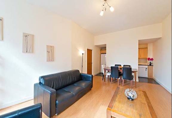 a living room with a leather couch and a wooden table