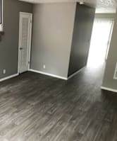 A room with a staircase and wooden flooring.