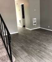 A room with a wooden floor and a door.