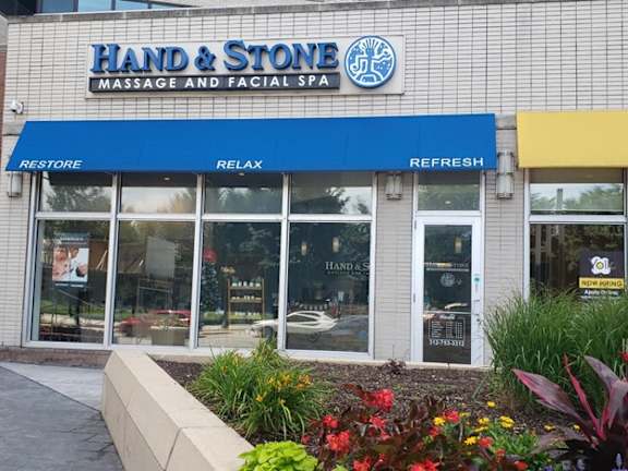 A storefront for a massage and facial spa with a blue awning.