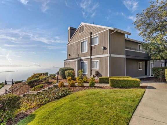 a home with a view of the water and a sidewalk