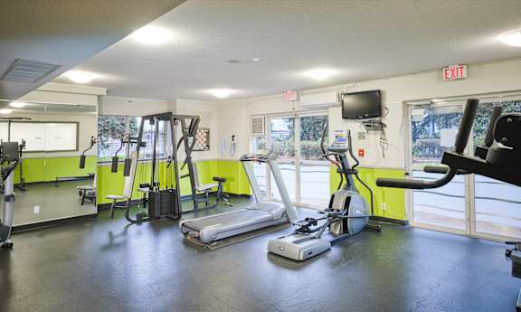 A gym with treadmills, elliptical machines, and other exercise equipment.
