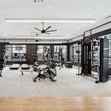 A spacious gym with a variety of equipment including treadmills, stationary bikes, and weight machines.