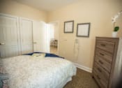 Thumbnail 16 of 31 - A bedroom with a bed, dresser, and two pictures on the wall.