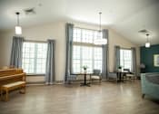 Thumbnail 24 of 31 - A room with a wooden bench and grey chairs.