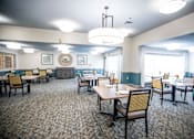 Thumbnail 9 of 29 - A dining room with tables and chairs and a chandelier.at Spring Arbor of Wilson, Wilson, NC