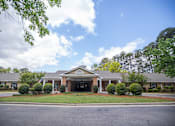 Thumbnail 14 of 29 - A building with a green lawn in front.at Spring Arbor of Wilson, North Carolina