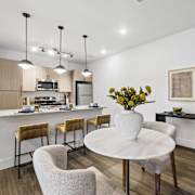 A modern kitchen with a dining table and chairs.