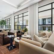 A living room with a brown sofa, a black coffee table, and a large window with a view of the city.