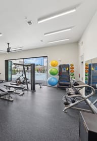 a gym with treadmills and other exercise equipment in a building with a window
