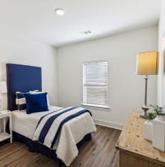 a bedroom with a bed and a dresser and a window