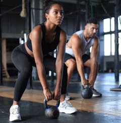 a man and a woman are in a gym holding dumbbells