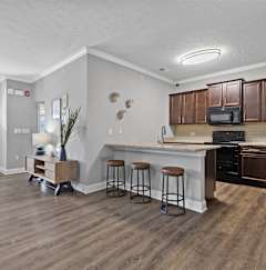 a kitchen with a breakfast bar and a living room with a couch