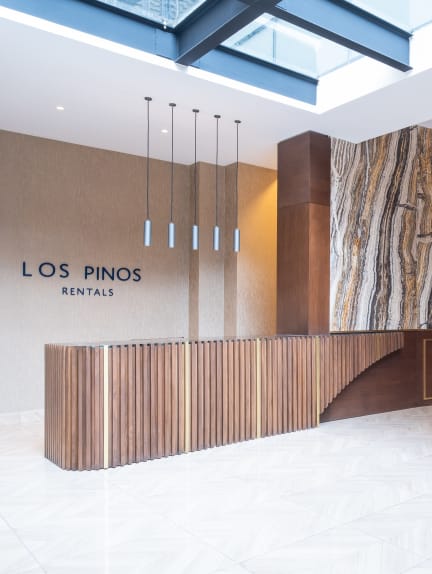 a large drum chandelier hangs from the ceiling in the lobby of the los pines