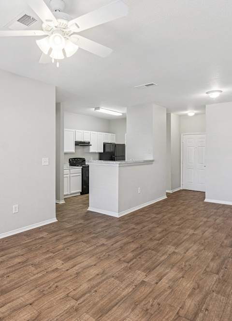 A kitchen with a sink, stove, and cabinets.