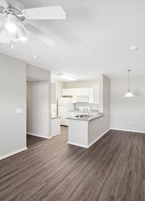 A kitchen with a sink, stove, and cabinets.