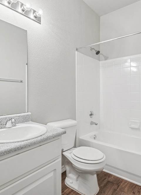 A white bathroom with a sink, toilet, and bathtub.