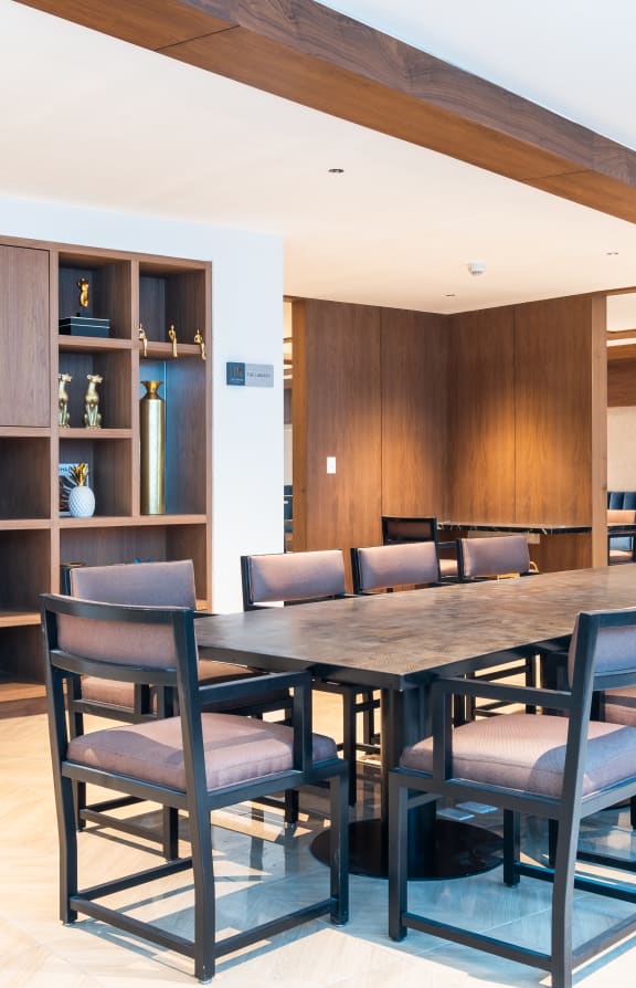 a long table with chairs and a bookshelf