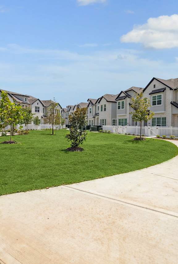 A residential area with houses and a green lawn.