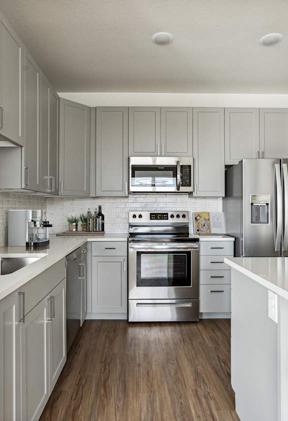 A modern kitchen with white cabinets and stainless steel appliances.