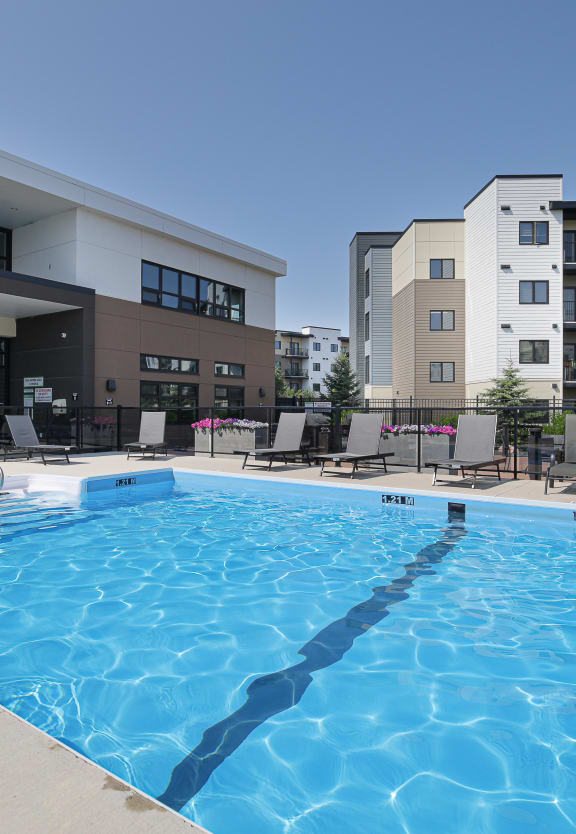 a large swimming pool in front of an apartment building