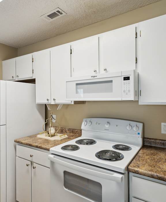 A kitchen with white appliances and cabinets.