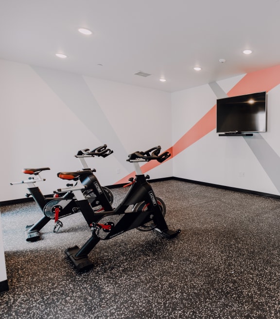 a gym with exercise equipment and a television on the wall