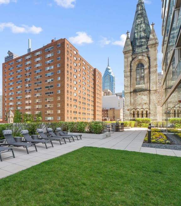 an outdoor terrace with chairs and a grassy area
