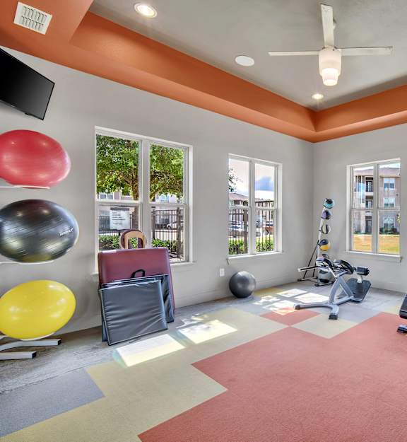a workout room with weights and cardio equipment at the grove apartments