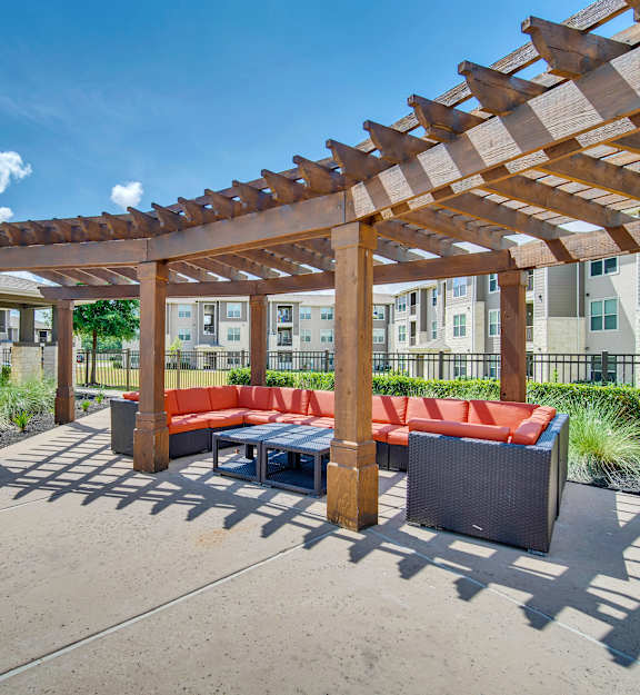 a furnished patio with a pergola and a table