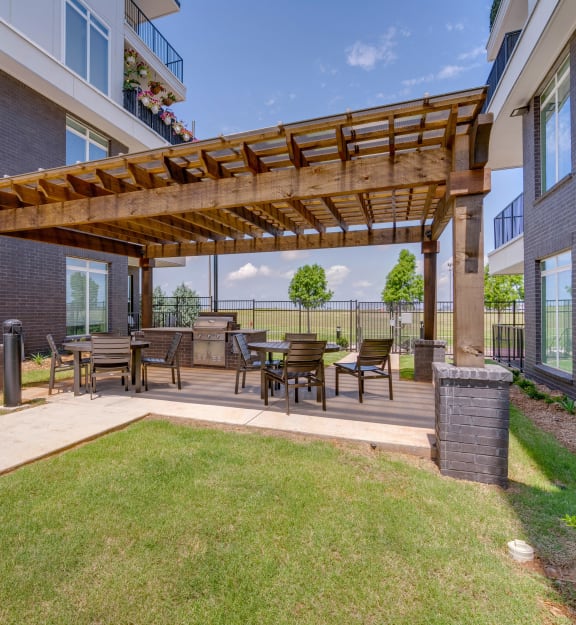 a patio with a pergola and a table and chairs
