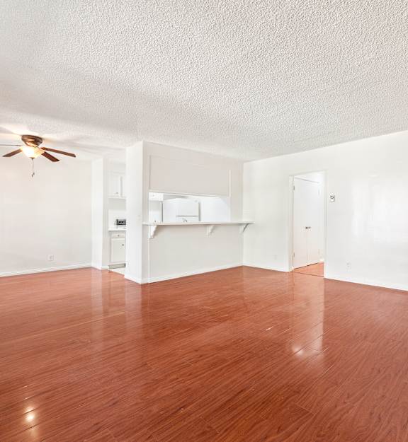 A room with wooden floors and a ceiling fan.