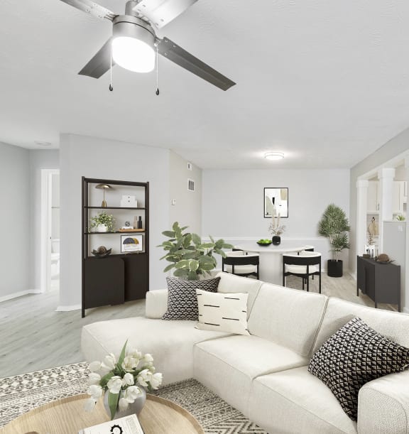 a living room with a white couch and a ceiling fan