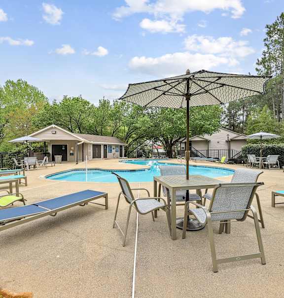 A pool area with a table and chairs and a canopy.