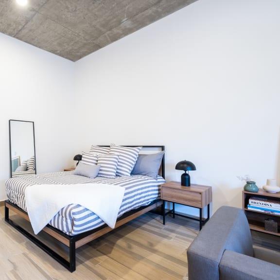 a bedroom with a bed and a chair in a 555 waverly unit