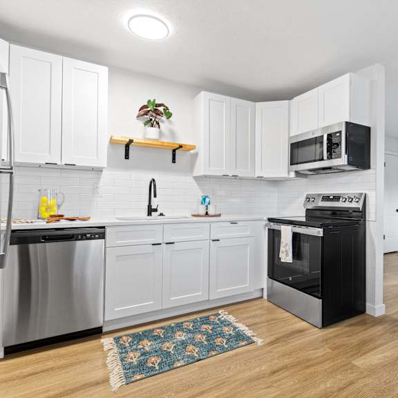 A kitchen with white cabinets and a black oven.
