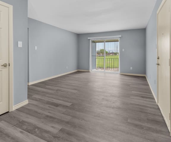 a bedroom with hardwood flooring and a door leading to a balcony