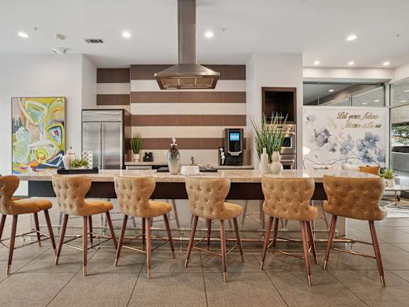 A modern kitchen with a large island and chairs.