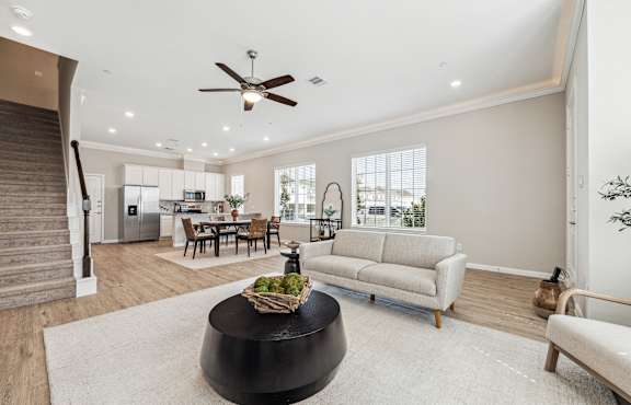 A modern living room with a black coffee table in the center.