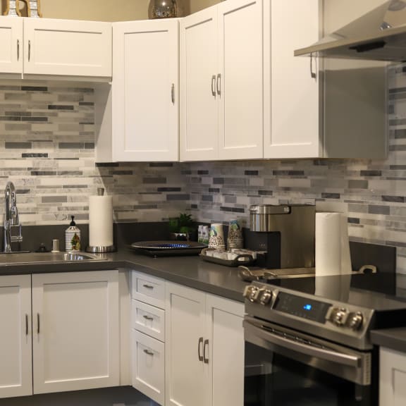 Spacious Kitchen with White Cabinetry and Unique Tile Backsplash at The Crossings at Redlands, in Redlands, CA, 92374