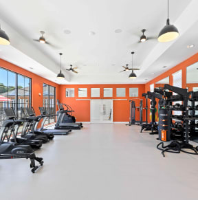a gym with exercise equipment and windows in the background