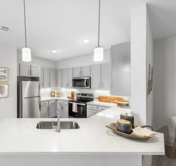 a kitchen with white countertops and stainless steel appliances