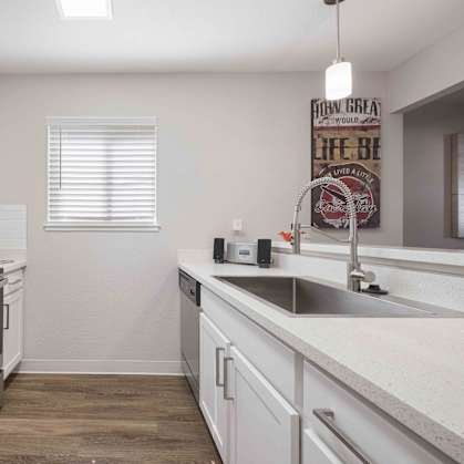 A kitchen with white cabinets and a black stove top oven.