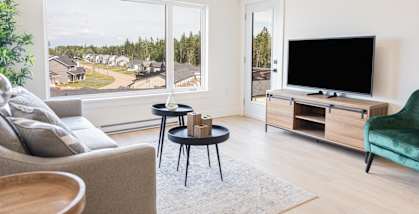 a living room with a large window and a couch and a tv