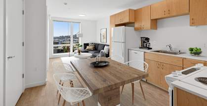 A kitchen with a table and chairs in front of a window.