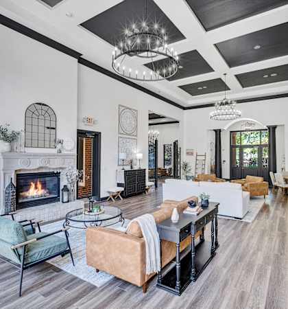 the living room has a fireplace and couches and a table with chairs